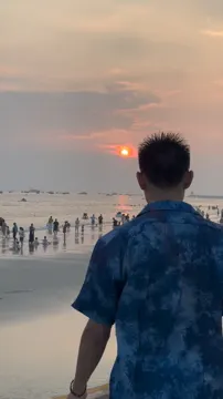 祖仁泽站在海边，望向夕阳