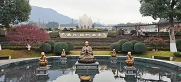 寺院庭院里的水池、雕像、花树与远处的山