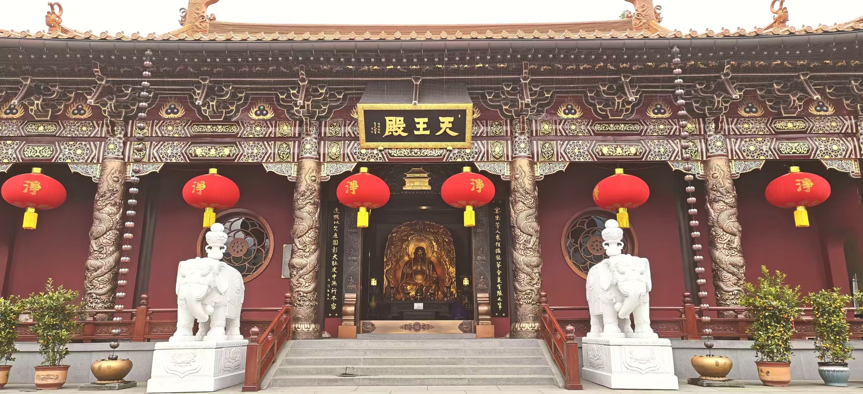 寺院天王殿前的石阶、雕花梁柱、红灯笼与石象