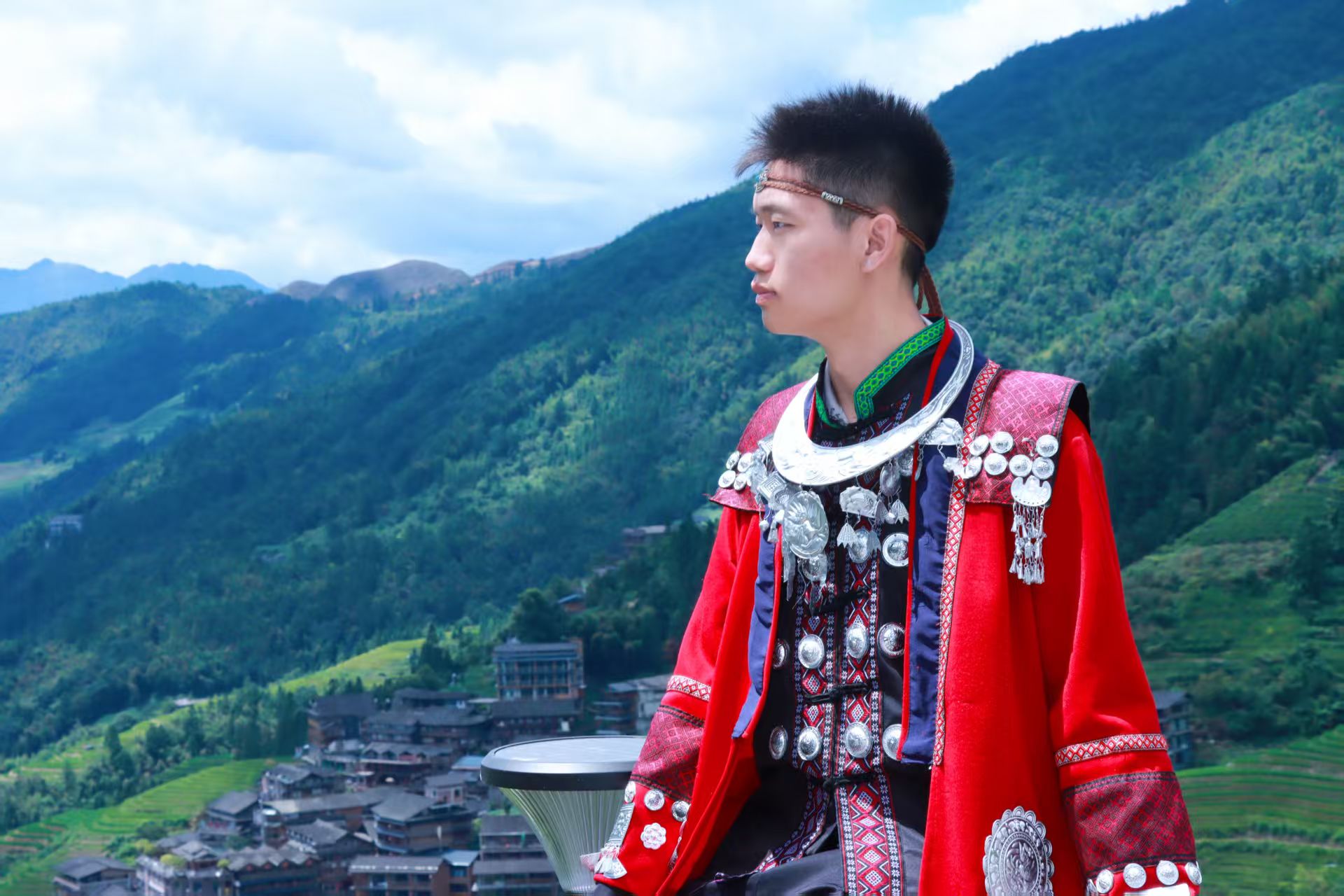 外出旅行体验红色民族服装,侧身望向远处的山林