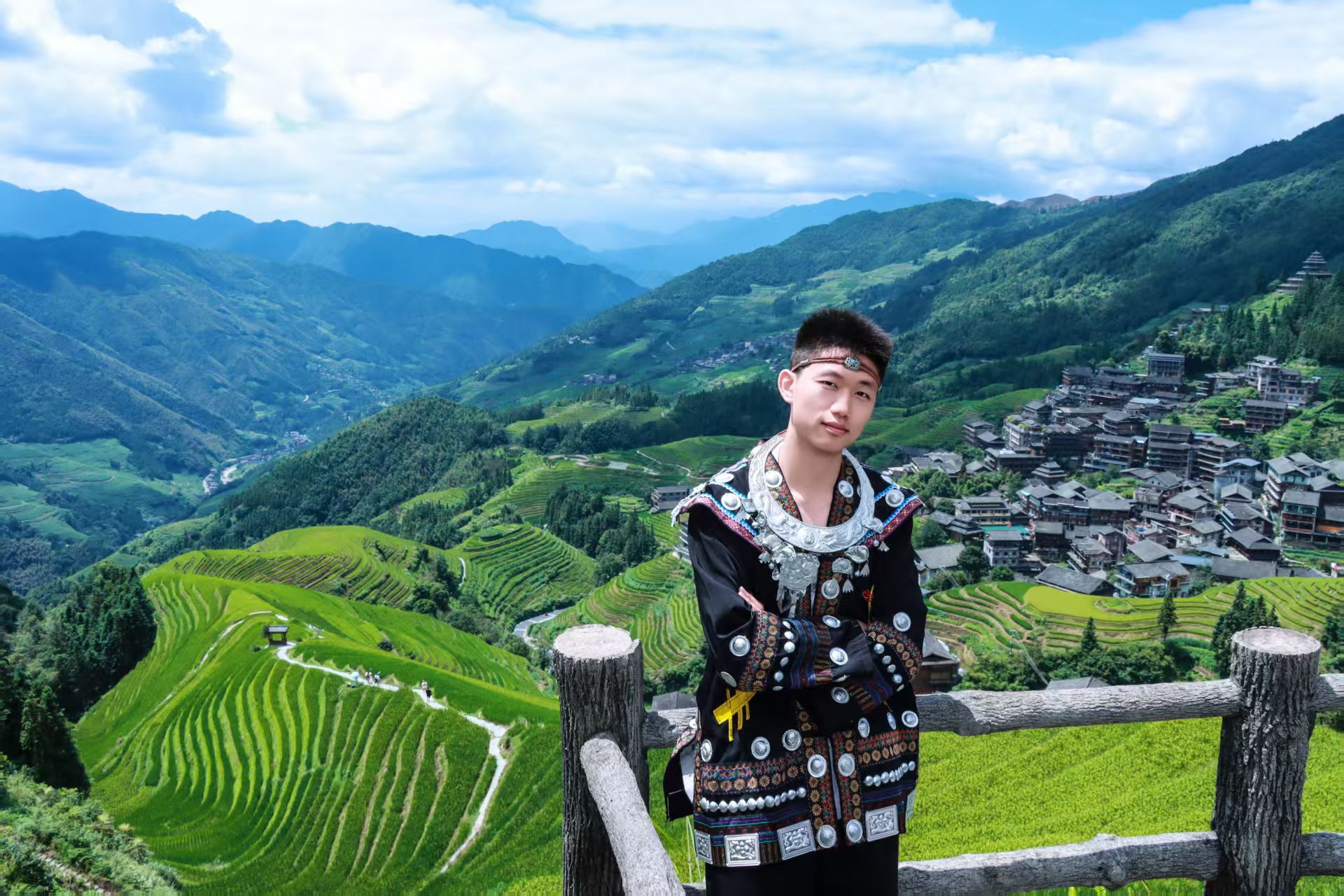 外出旅行体验黑色民族服装,身后是梯田和木质建筑群