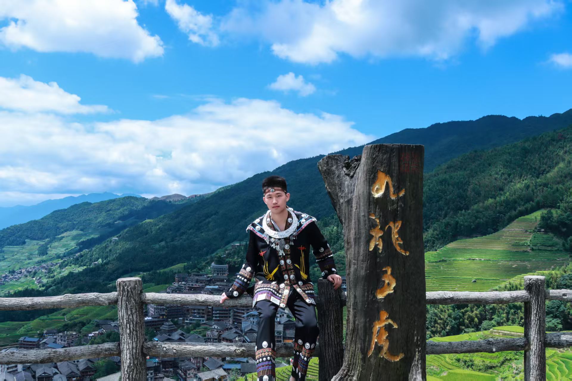 外出旅行体验黑色民族服装,站在木质观景标牌旁