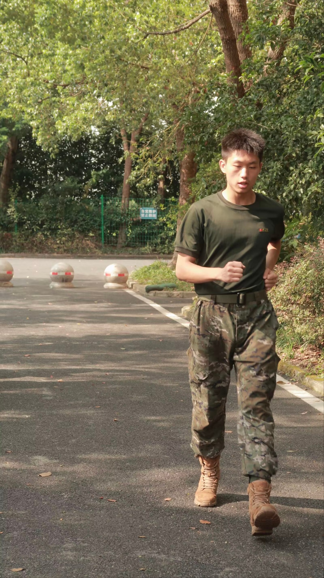 祖仁泽穿着绿色上衣,在户外跑步